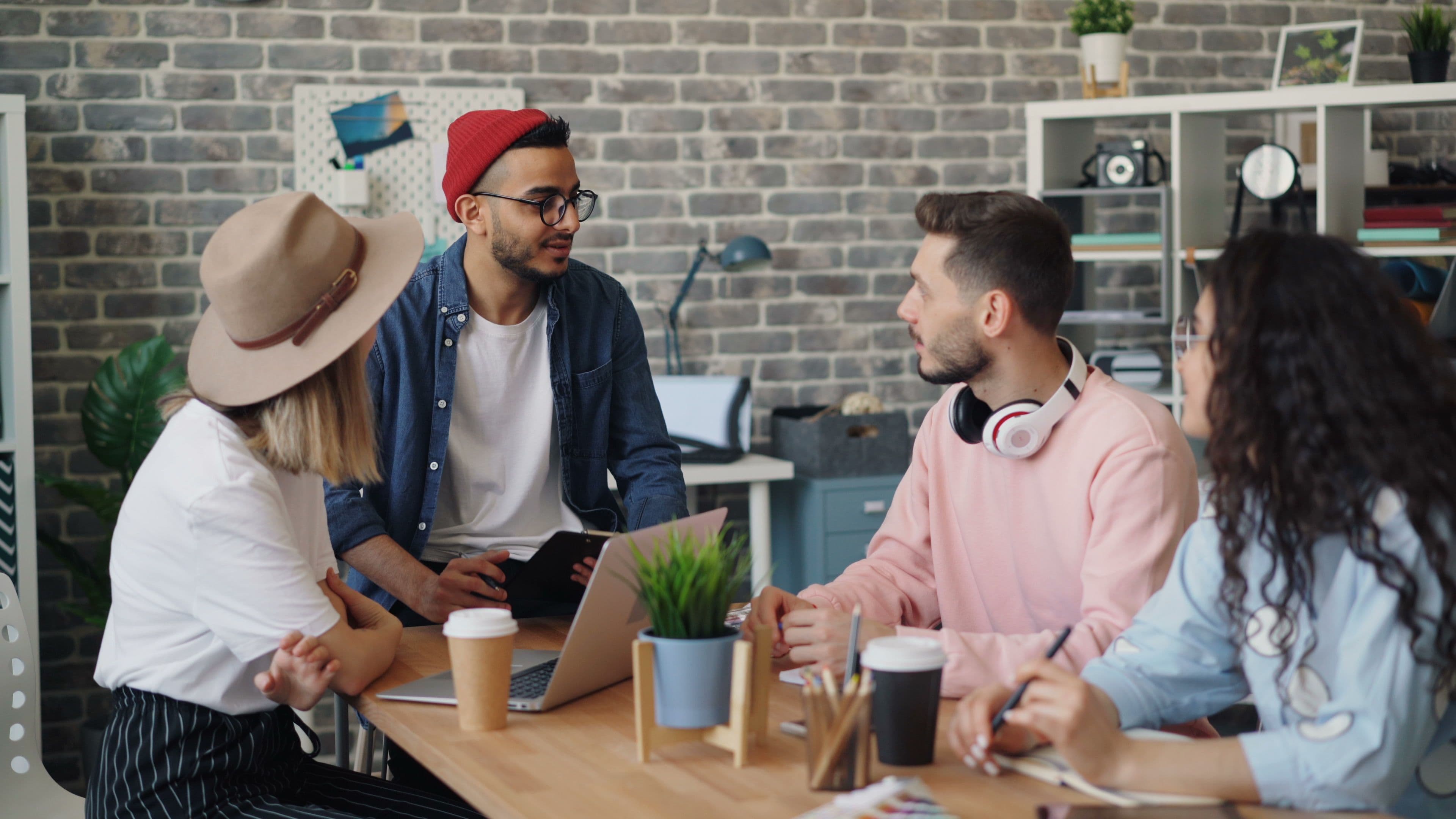 A Nidham team meeting in progress around a studio table